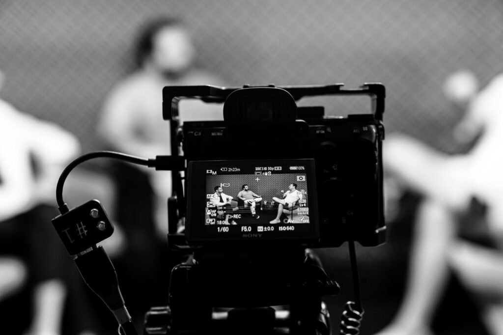 pexels photo 31656366 Camera capturing an indoor interview scene, in focus with a blurred background.