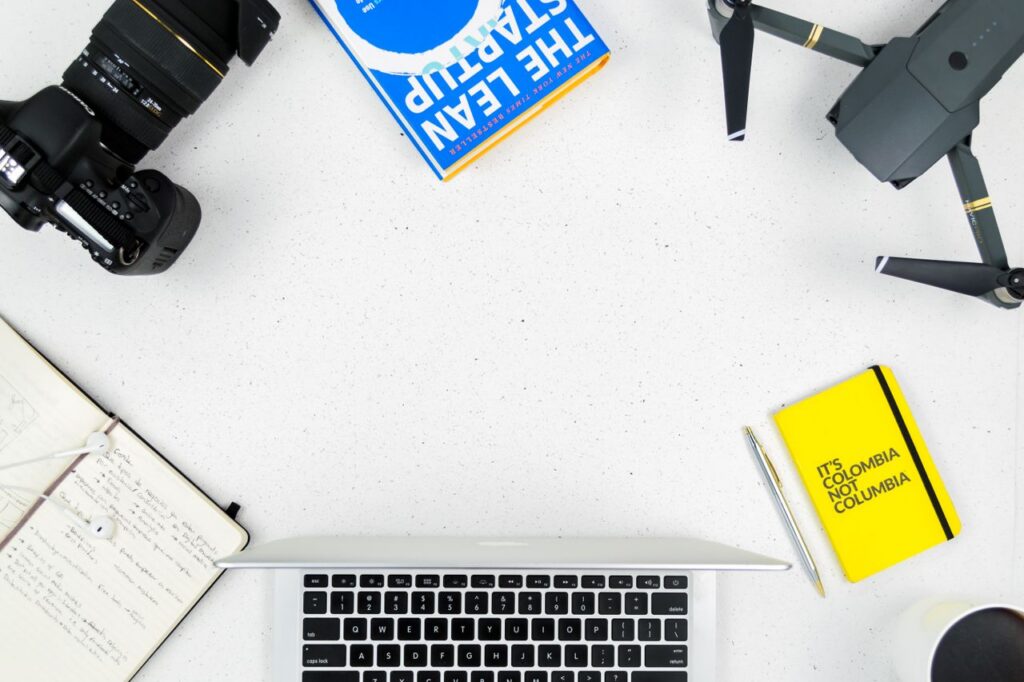 pexels photo 9510681 Flat lay of a creative workspace featuring a camera, drone, and laptop on a white surface.